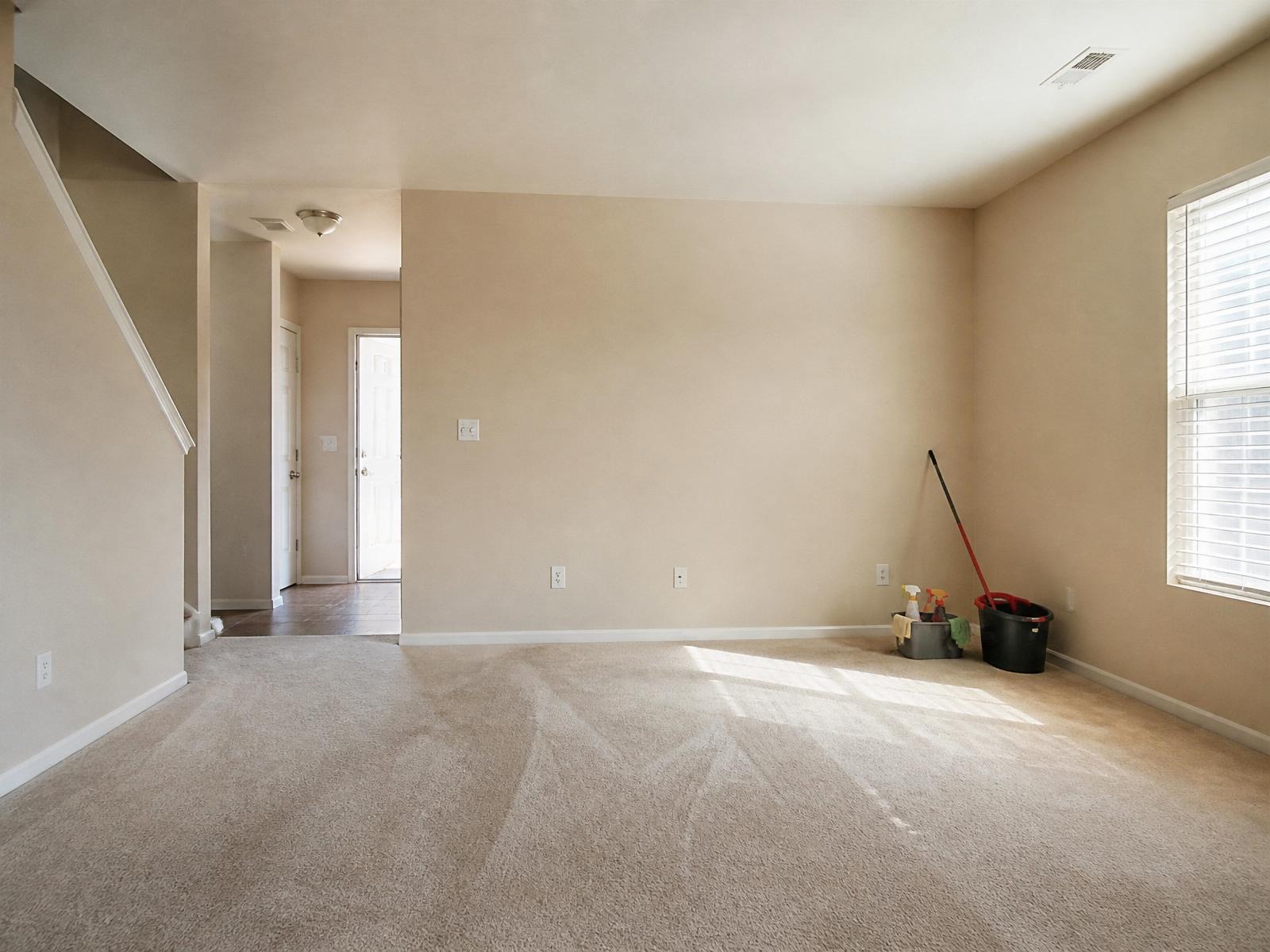 Empty rental home interior mid-turnover with cleaning supplies